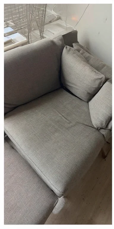 Grey fabric 2-seater sofa with embedded dust and dirt before professional deep cleaning in Dubai Marina UAE
